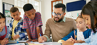 Homepage-education-bucket male teacher helping a group of young kids